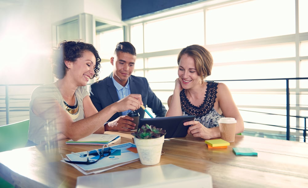 Image of three succesful business people using a tablet during at meeting-1